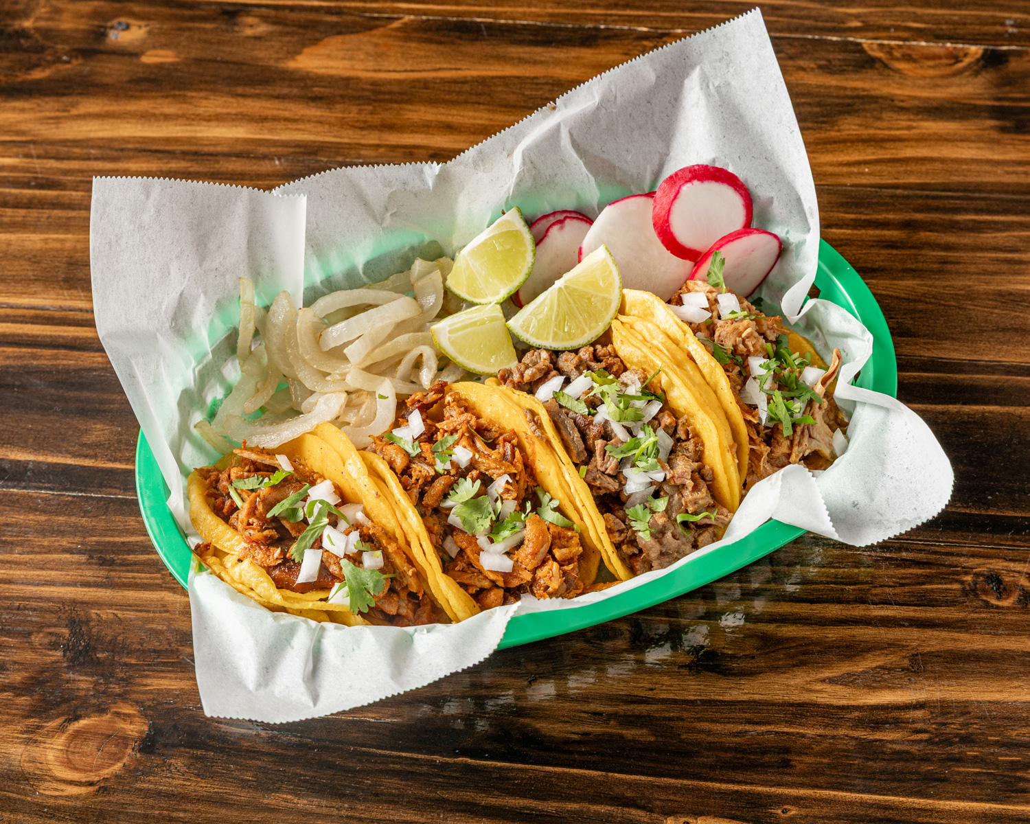 Taco bar setup with carne asada, al pastor, fresh tortillas and toppings
